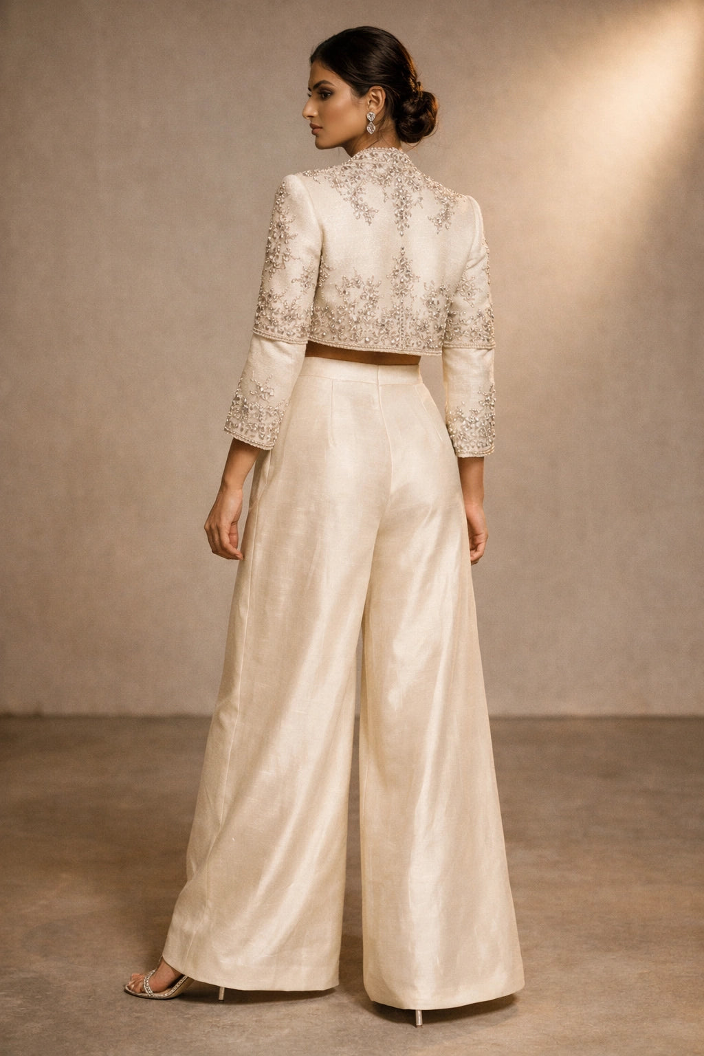 Ivory formal jacket and wide-leg pants set with embellished bustier by Miraam, styled in a luxury editorial setting