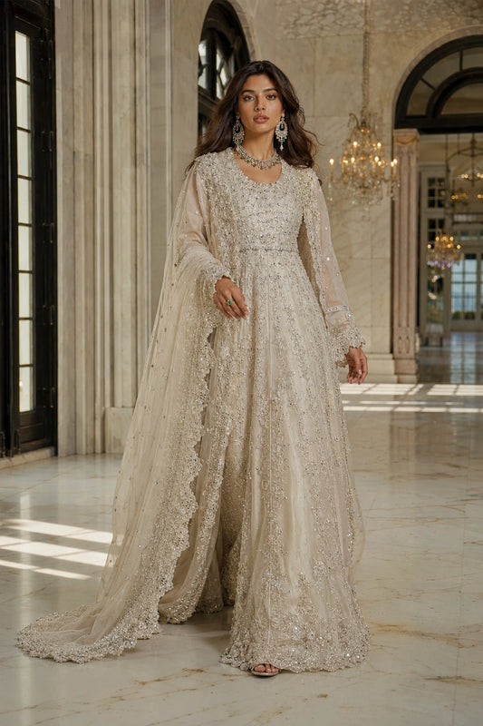 Model wearing an ivory sheesha silk bridal pishwas with intricate crystal embroidery and embellished net dupatta in a luxury palace-inspired setting by Miraam.