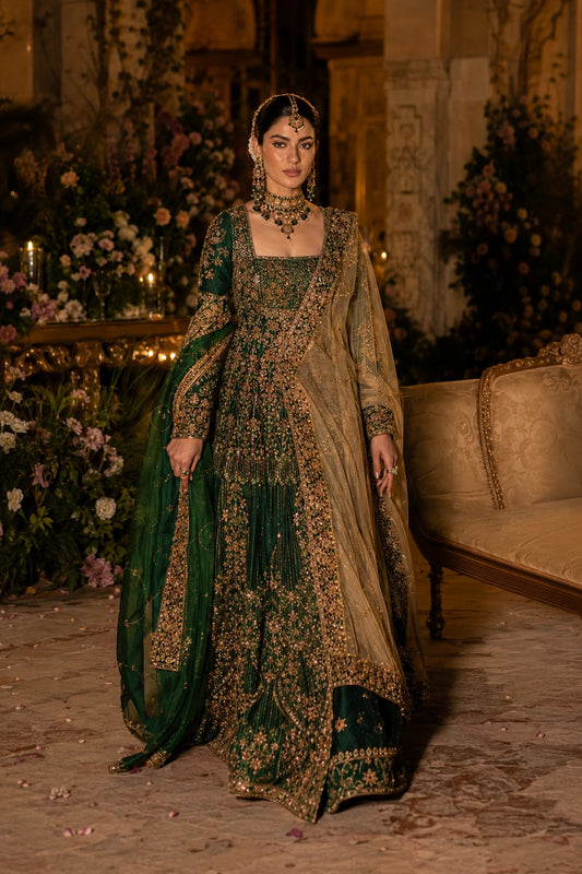 Model wearing an emerald green Korean silk bridal peplum lehenga with intricate gold embellishment and double-shade organza dupatta in a luxurious wedding setting by Miraam.