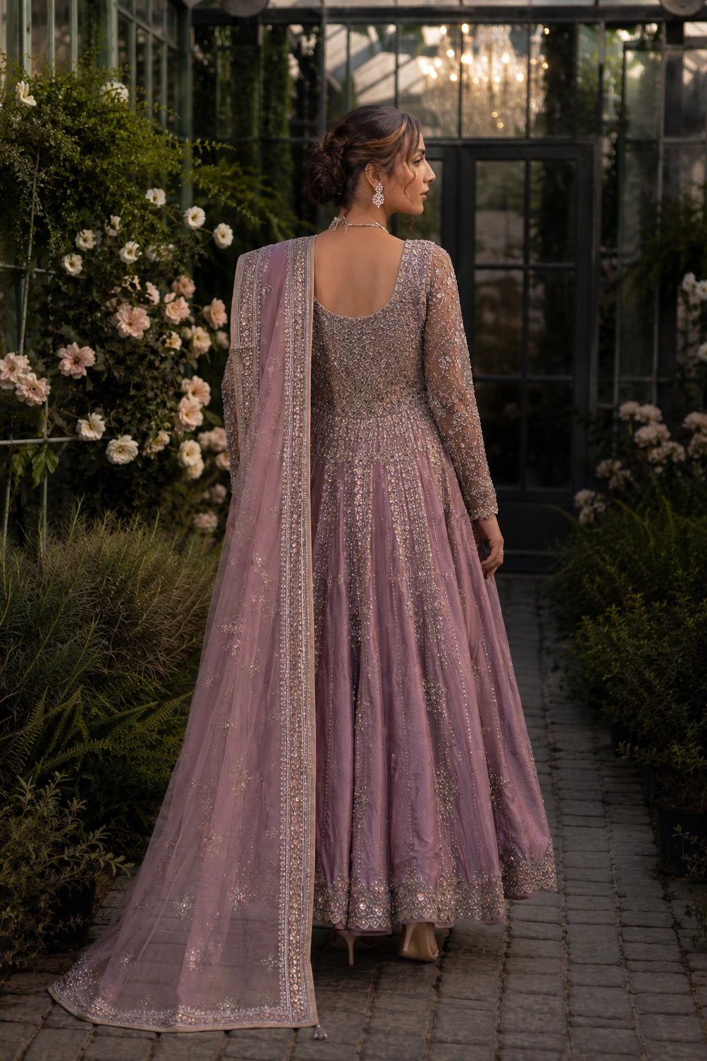 Model wearing a mauve sheesha silk bridal pishwas with intricate embellishment and embroidered organza dupatta in a luxury garden-inspired setting by Miraam.