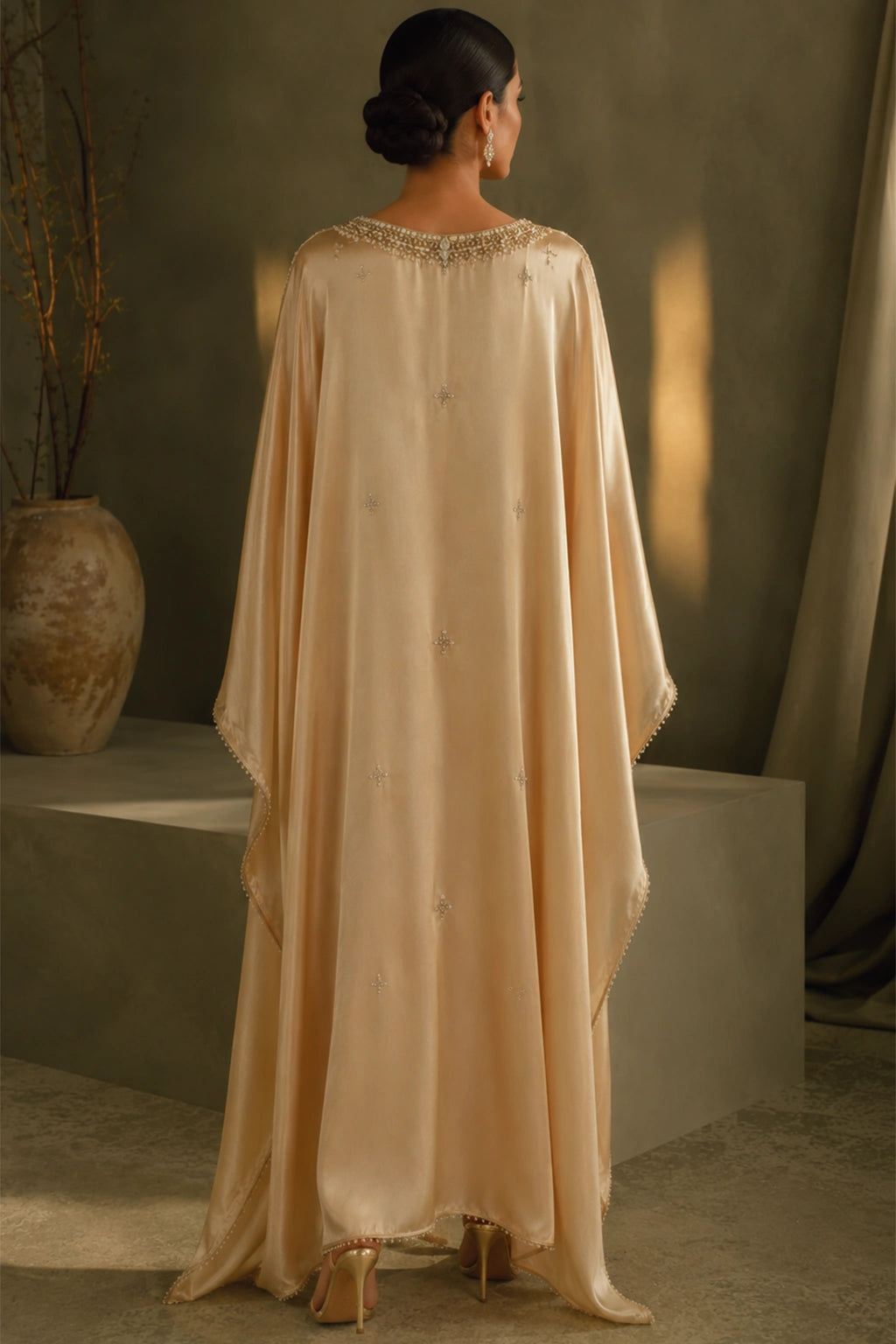 Solène Champagne by Miraam featuring a flowing champagne sheesha silk kaftan with an embellished neckline and elegant draped sleeves.