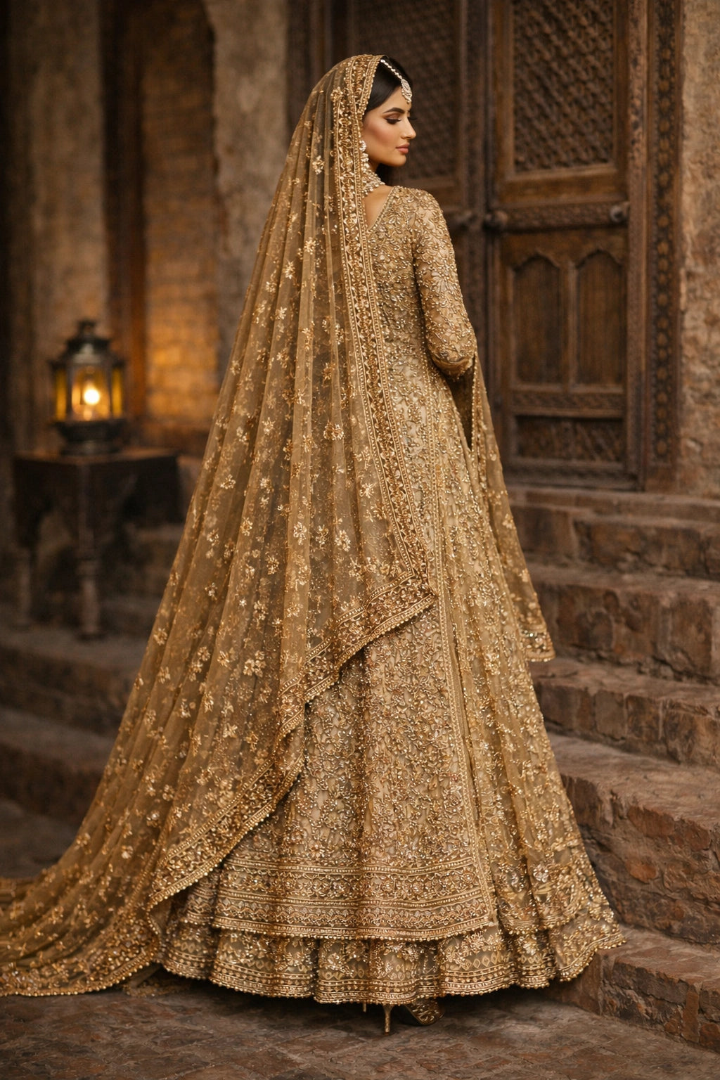 Bride wearing champagne gold embroidered bridal gown with lehenga and dupatta in heritage architectural setting