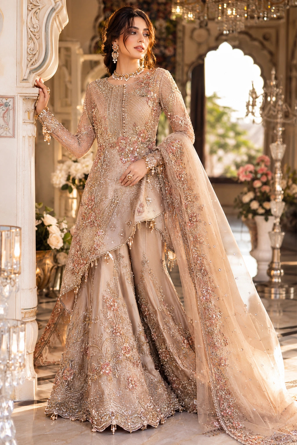 Woman wearing a blush beige Korean silk asymmetrical shirt with embellished sharara and embroidered organza dupatta by Miraam