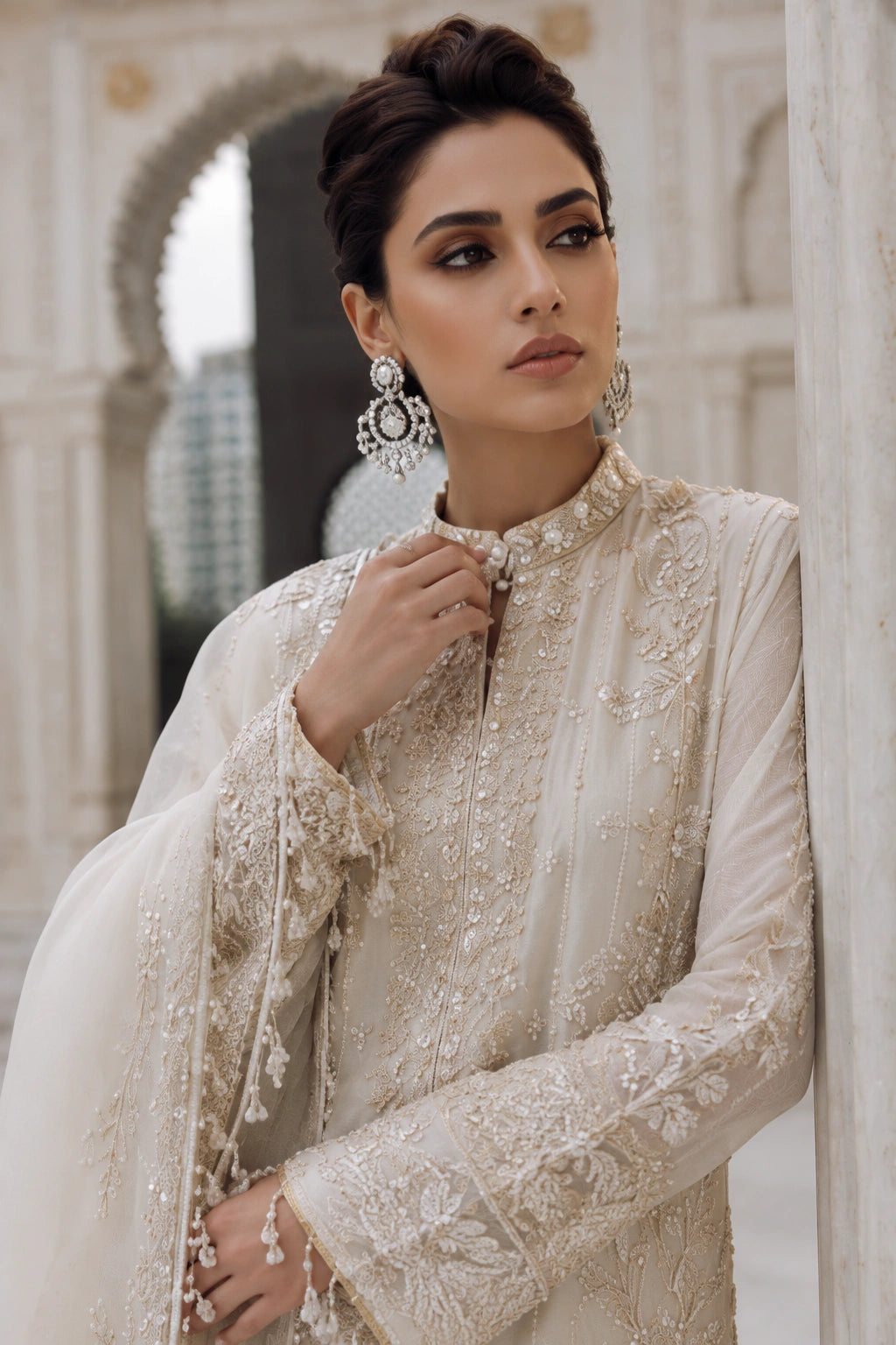 Woman wearing an ivory raw silk embroidered shirt with wide-leg pants and embellished organza dupatta by Miraam