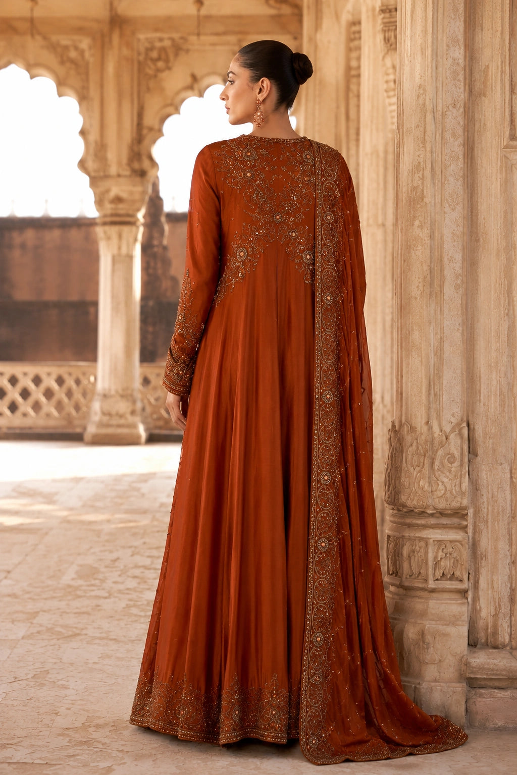 Woman wearing an amber raw silk angrakha shirt with embellished organza dupatta by Miraam