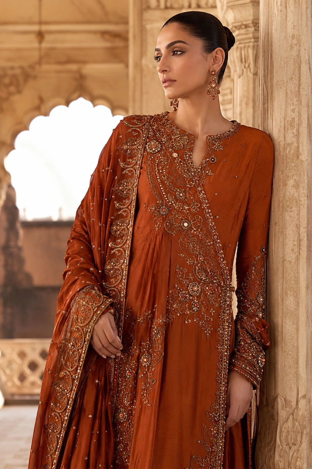 Woman wearing an amber raw silk angrakha shirt with embellished organza dupatta by Miraam