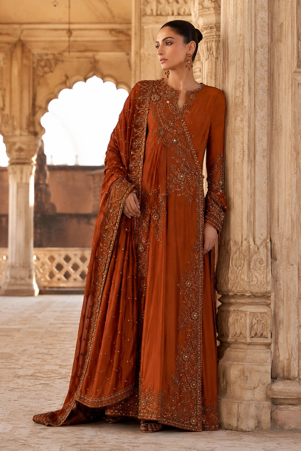 Woman wearing an amber raw silk angrakha shirt with embellished organza dupatta by Miraam