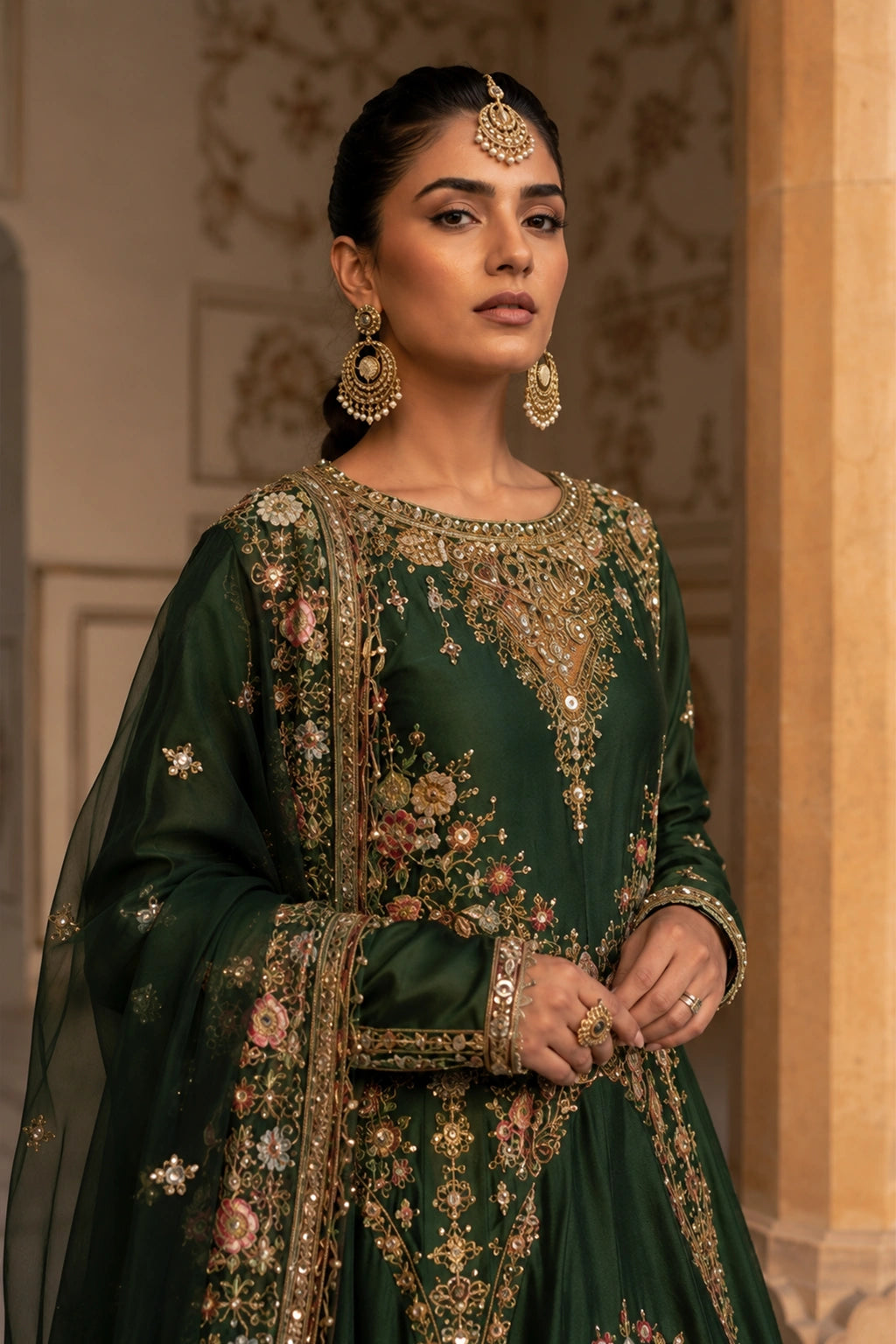 Woman wearing an emerald green raw silk pishwas with embroidered organza dupatta by Miraam