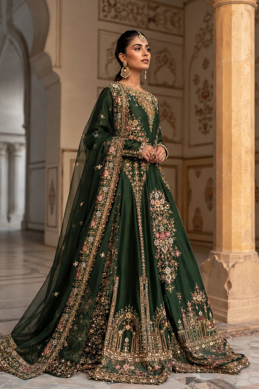 Woman wearing an emerald green raw silk pishwas with embroidered organza dupatta by Miraam