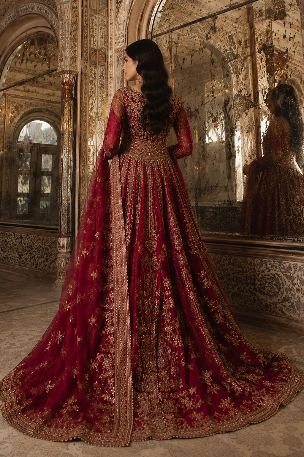 Woman wearing a deep ruby raw silk embellished pishwas with embroidered organza dupatta by Miraam