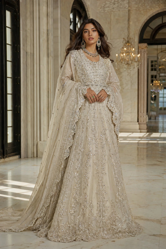 Model wearing an ivory sheesha silk bridal pishwas with intricate crystal embroidery and embellished net dupatta in a luxury palace-inspired setting by Miraam.
