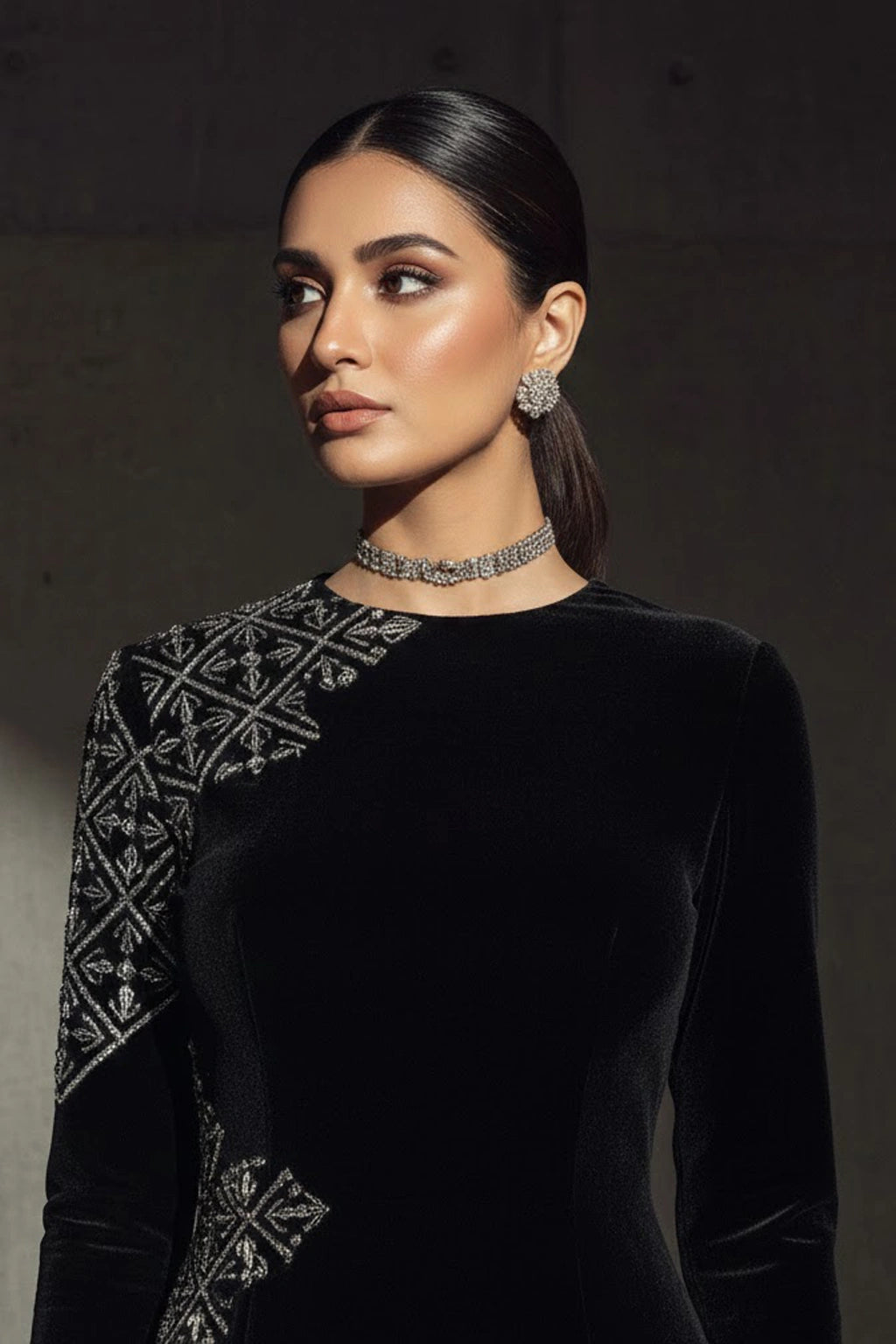 Black velvet couture gown featuring subtle asymmetric embellishment and a sculptural silhouette by Miraam.