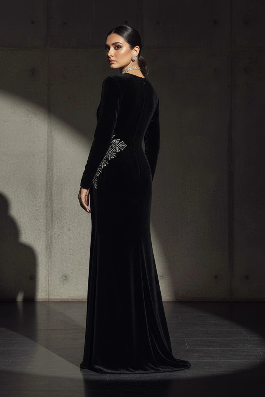 Black velvet couture gown featuring subtle asymmetric embellishment and a sculptural silhouette by Miraam.