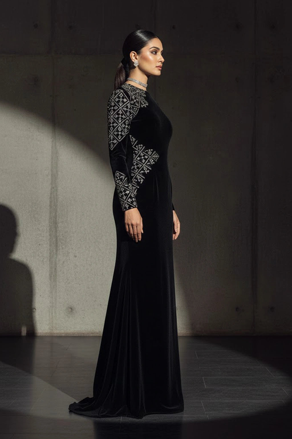 Black velvet couture gown featuring subtle asymmetric embellishment and a sculptural silhouette by Miraam.
