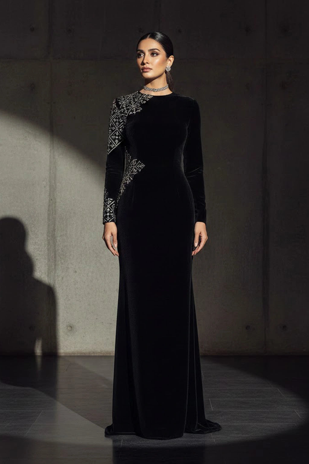 Black velvet couture gown featuring subtle asymmetric embellishment and a sculptural silhouette by Miraam.
